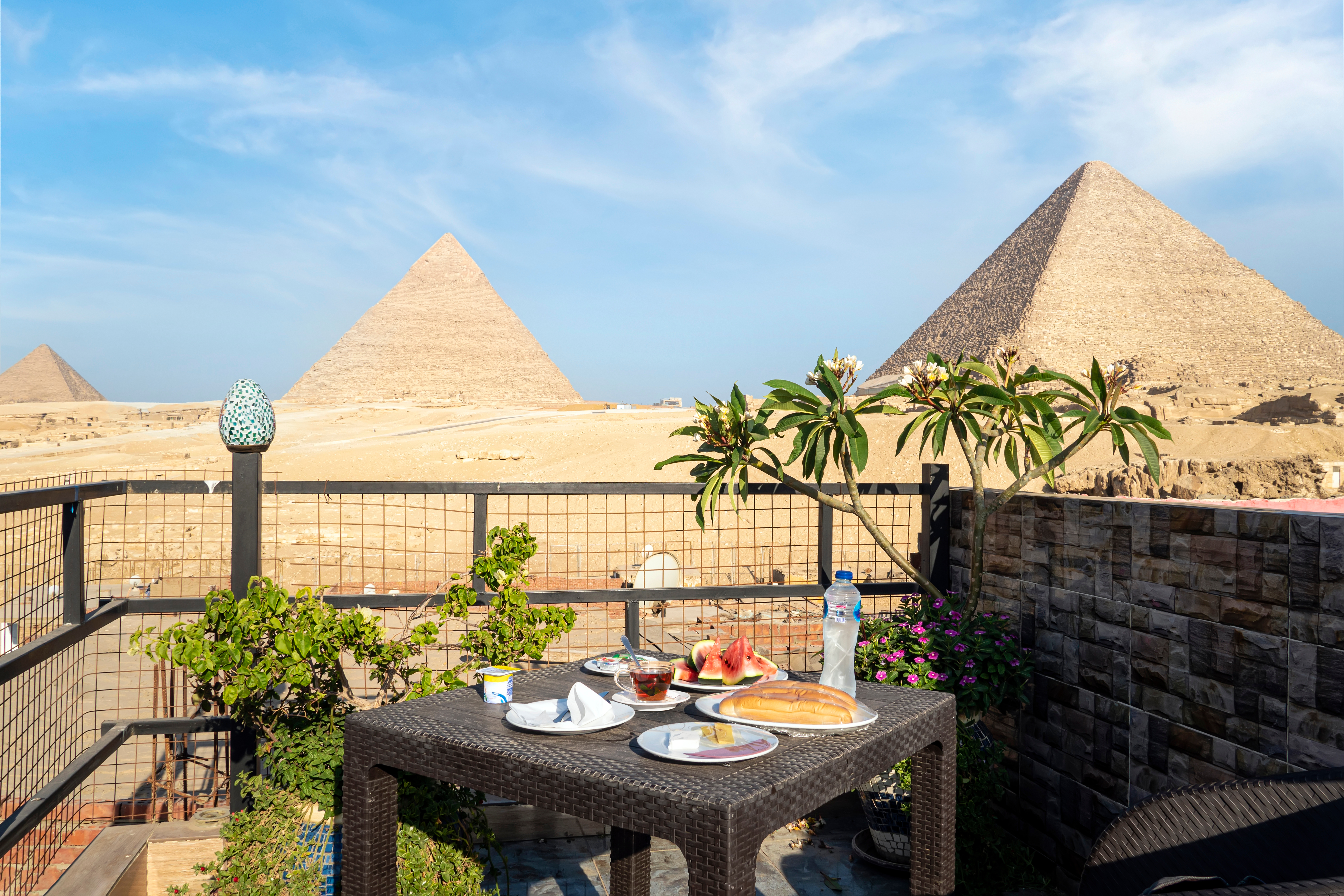 A table in an outdoor restaurant with a fantastically beautiful view of the great pyramids of Giza. Cairo.
